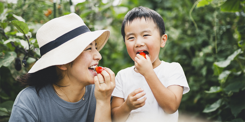 mother and child eating tomato