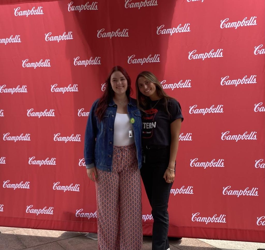 two woman in front of campbell logo