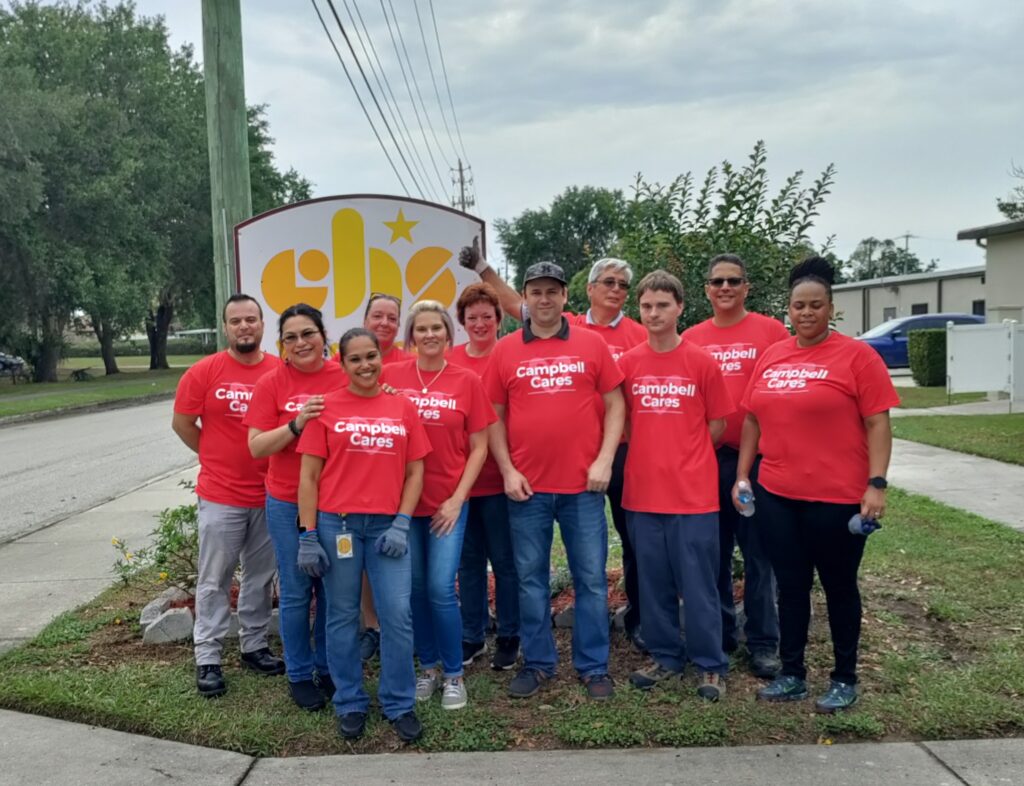 Campbell employees in Lakeland outside of the CHS sign